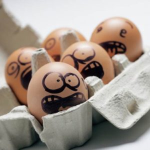 Eggs in a carton with faces drawn on them